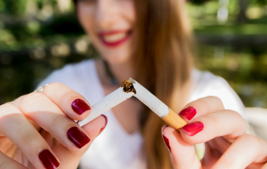 Person breaking a cigarette in half.